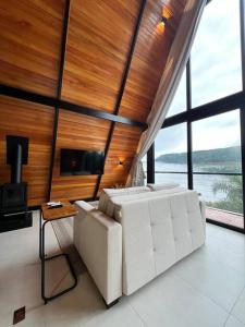 - une chambre avec un canapé blanc et une grande fenêtre dans l'établissement Cabanas 96, à Bento Gonçalves