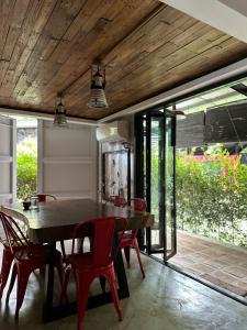 une salle à manger avec une table en bois et des chaises rouges dans l'établissement OFF THE GRID - Imagined adventures in a relaxing escape, à Alfonso