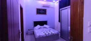 ein lila Zimmer mit einem kleinen Bett darin in der Unterkunft فندق الفخامة in El-Qaṭṭa
