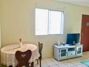 uma sala de jantar com uma mesa e uma televisão em Apartamento Mobiliado em Piracicaba Centro em Piracicaba