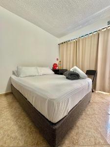 a bedroom with a large bed with white sheets at Luky's Rooms in San Andrés