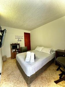 a bedroom with a bed with two pillows on it at Luky's Rooms in San Andrés