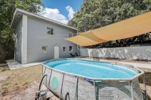 una piscina frente a una casa con una sombrilla grande en Luxury Miami 4BR Home with Pool, Next to Wynwood & South beach en Miami