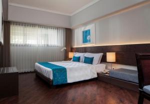 Habitación de hotel con cama y sofá en Prime Plaza Suites Sanur – Bali en Sanur