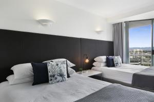 a bedroom with two beds and a large window at Studio with Resort Facilities in Prime Location in Gold Coast