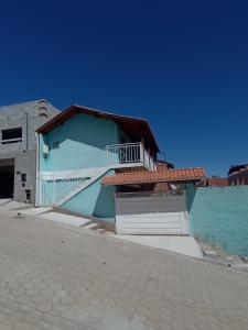 a blue building with a balcony and a garage at Recanto lavinia in Monte Verde