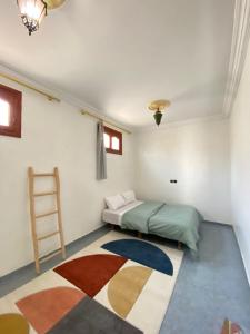 a bedroom with two beds and a rug on the floor at Surfpoint Tamraght in Tamraght Oufella