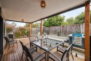 a patio with a glass table and chairs on a deck at Seagrove Retreat Cowes in Cowes