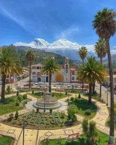 a park with palm trees in front of a building at Casa acogedora en Mancos, Yungay in Yungay
