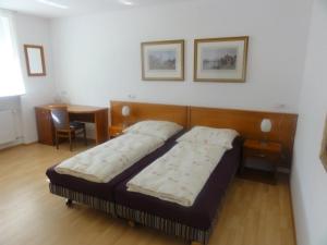 a bedroom with a bed and a table with a chair at Hotel Mila in Reichenbach an der Fils