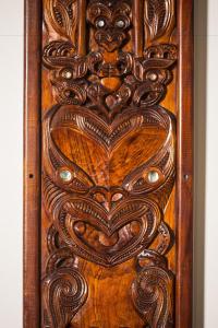 eine Holztür mit aufwendigem Design darauf in der Unterkunft Marsden Stay Rotorua in Rotorua