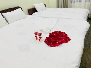Vĩnh PhúcにあるWhite House - Nhà khách Báo nhân dân TAM ĐẢOの赤いバラとワインのグラスが付いたベッド2台