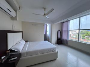 a bedroom with a bed and a ceiling fan at Hotel Kingfisher - Barishal in Barisāl
