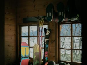 白馬村にあるCottage Snowhills Hakuba - Vacation STAY 94871vの壁にスノーボードが付いた窓2つが備わる客室です。
