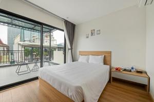a bedroom with a bed and a large window at 22Housing Luxury Apartment 81 Linh Lang in Hanoi