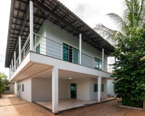 a white building with a balcony on top of it at Suíte 1 - Pousada Karaiba in Uberlândia