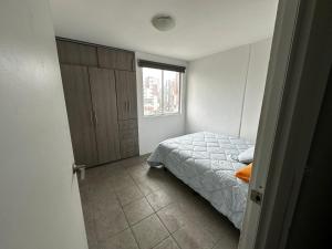 een kleine slaapkamer met een bed en een raam bij Encantador Departamento en Xalapa in El Castillo