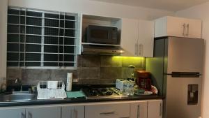 a kitchen with a stove and a microwave at Encantador Departamento en Xalapa in El Castillo