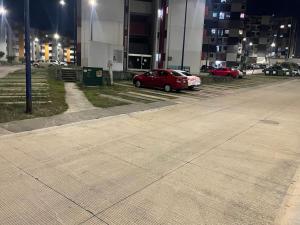 czerwony samochód zaparkowany na parkingu w nocy w obiekcie Encantador Departamento en Xalapa w mieście El Castillo