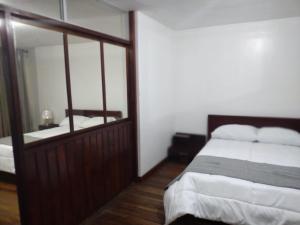 a bedroom with a bed and a large mirror at Hermoso Departamento in Loja