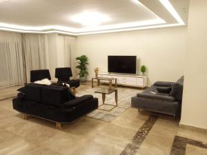a living room with two couches and a flat screen tv at شقق فندقية فاخرة in Cairo