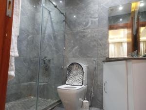 a bathroom with a toilet with a glass shower at شقق فندقية فاخرة in Cairo