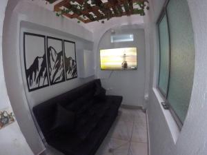 a living room with a black couch and a window at Right in the heart of Medellin in Medellín