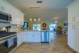 a large kitchen with white cabinets and blue appliances at New Resort Style Oasis ~ LED Pool & Game Room in Minneola