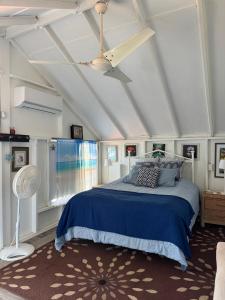 um quarto com uma cama azul e uma ventoinha de tecto em Bungalow Ocean View wifi em Patillas
