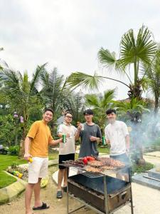 un groupe d'hommes debout autour d'un barbecue dans l'établissement Đông Sơn Mountain Villa, à Bắc Ninh