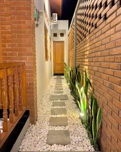 a walkway in a house with a brick wall at Omah Tabon Jogja - Dekat Dengan Malioboro in Timuran