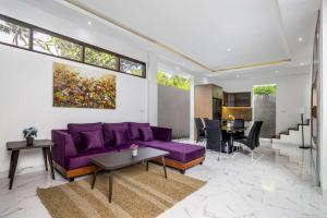 a living room with a purple couch and a table at Villa Sun Lila by JB Villas in Seminyak