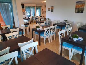 a restaurant with tables and white chairs and tables and chairsktop at Gulliver Delta Resort in Murighiol