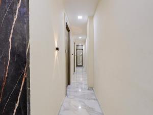 einen Flur mit weißen Wänden und Marmorböden in der Unterkunft OYO HOTEL KING View in Ahmedabad