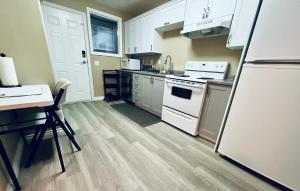 a kitchen with white appliances and a wooden floor at Marine Melody in Nanaimo