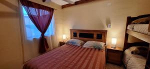 1 dormitorio con 2 camas y ventana en casa saire en San Pedro de Atacama
