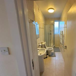 uma casa de banho com 2 WC e um lavatório em Wembley Stadium Serviced Apartment 2, 12mins to Central London em Londres