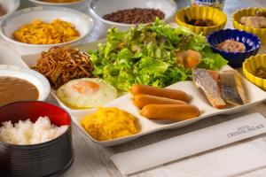 a plate of food with rice and vegetables and other dishes at Hotel Crystal Palace in Hitachinaka