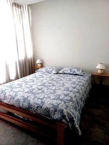 a bedroom with a bed with a blue comforter at Estreno: Cómodo y céntrico Dpto. en Caraz Dulzura. in Caraz