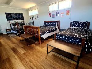 a room with three beds and a table at The Corner Store B&B entire property in Stawell