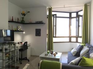 sala de estar con sofá, mesa y escritorio en Mai Apartment, en Las Palmas de Gran Canaria