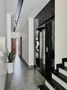 a hallway with a black marble wall and stairs at Hula Hotel in Can Tho +20 photos