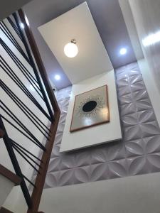 una scala a chiocciola con orologio sul soffitto di House of two levels in Cavite, Lancaster New City GL1 a General Trias