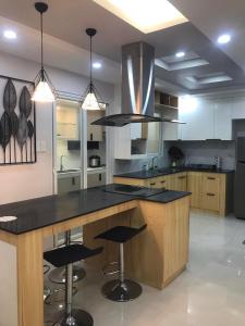 una cucina con ampia isola e ripiani neri di House of two levels in Cavite, Lancaster New City GL1 a General Trias