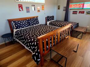 two beds in a room with wooden floors at The Corner Store B&B entire property in Stawell