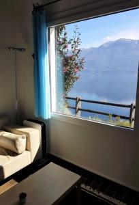 Zimmer mit einem großen Fenster mit Blick auf das Wasser in der Unterkunft Casa "Pipistrello" in Ronco sopra Ascona