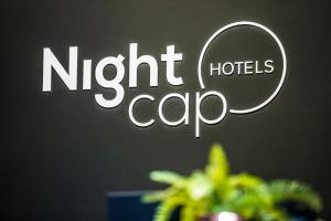 uma placa que diz café de hotel à noite numa parede em Nightcap at Horse & Jockey Hotel Warrick em Warwick