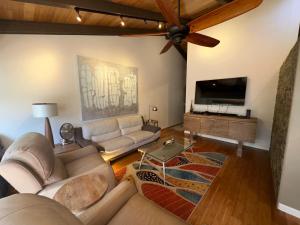 a living room with a couch and a flat screen tv at Modern Kahana getaway in Kahana