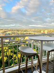 a balcony with two tables and a view of a city at 17Eleven Staycation Home in Manila