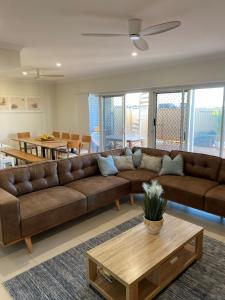 sala de estar con sofá marrón y mesa en 35 Bluefin Cove, en Exmouth